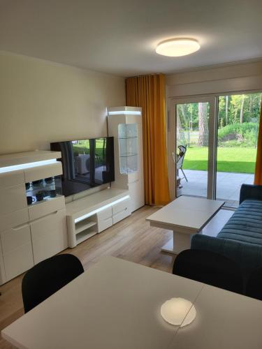 ein Wohnzimmer mit Sofa und Fernseher in der Unterkunft Plażowa Park 13 Międzywodzie in Międzywodzie