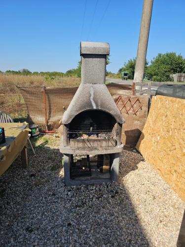 a outdoor oven with a pile of fire wood at Ca la noi acasă in Costinesti
