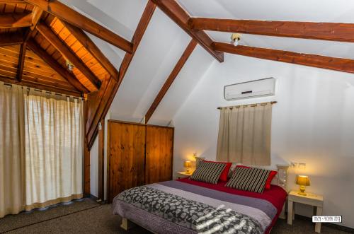 a bedroom with a bed in a room with wooden ceilings at Beautiful Lake View Wooden House in Tiberias