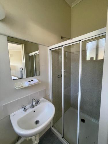 a bathroom with a sink and a shower at The Highlander Motel - 24HR Check In in Maryborough