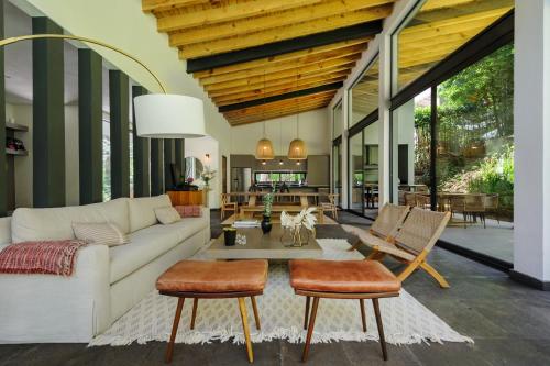 a living room with a white couch and chairs at Casa Helechos, Arquitectura Única con Vistas al Bosque in Valle de Bravo