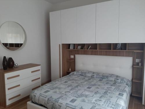 a bedroom with a bed and a dresser and a mirror at Arona Lovely House in Arona