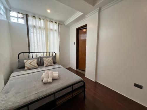 a bedroom with a bed with two towels on it at Bahay Huni Boracay in Boracay