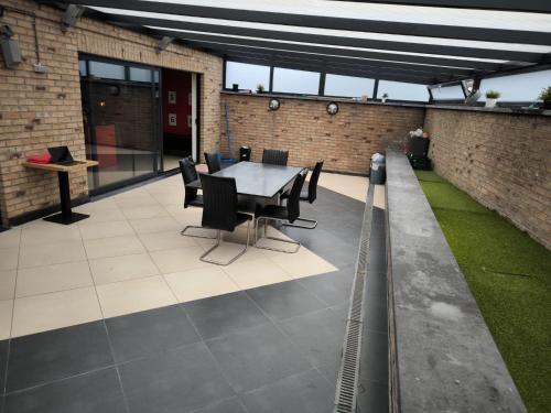 a patio with a table and chairs in a building at 8 chambres privées dans une villa de luxe partagée de 350m2 in Charleroi