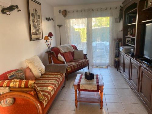 un salon avec un canapé et une table basse dans l'établissement Résidence Les jardins de Courseulles F3, à Courseulles-sur-Mer