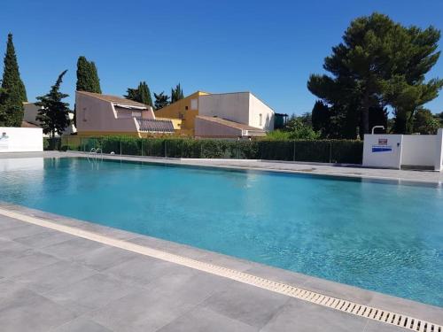 une piscine avec de l'eau bleue devant un immeuble dans l'établissement Cap d'Agde - Bel appartement 4 pers avec piscine, au Cap d'Agde