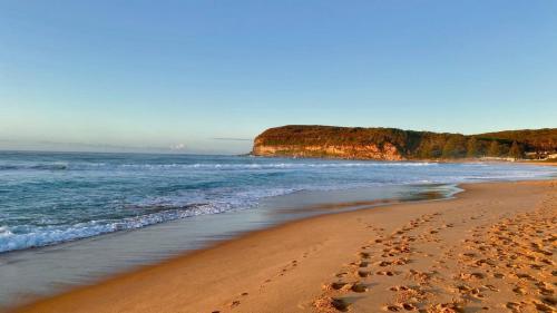 a beach with footprints in the sand and the ocean at Short Walk To Beautiful Copacabana Beach & Lagoon in Copacabana