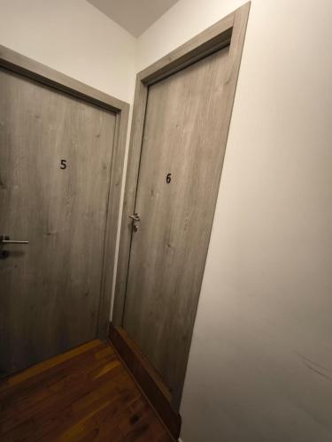 a pair of doors in a room with wooden floors at 8 chambres privées dans une villa de luxe partagée de 350m2 in Charleroi