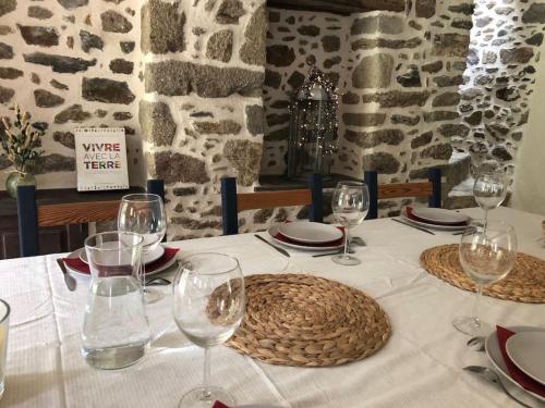 - une table avec un chiffon de table blanc et des verres à vin dans l'établissement La Terre Ferme - Au cœur d'une ferme maraîchère, à Saint-Lunaire