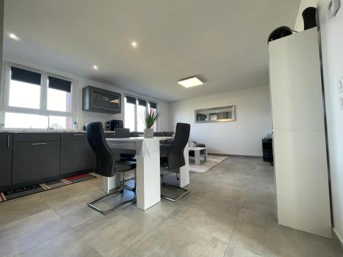 un bureau avec une table blanche et des chaises noires dans l'établissement Appartement T3 en centre-ville de Thonon-Les-Bains, à Thonon-les-Bains