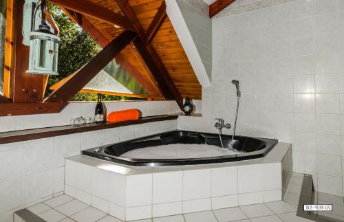 a bath tub in a room with a window at Beautiful Lake View Wooden House in Tiberias