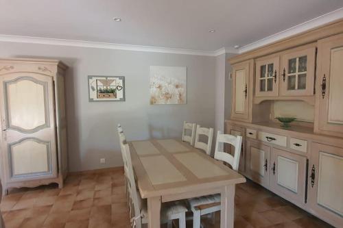 - une cuisine avec une table, des chaises et une porte dans l'établissement Villa proche des Alpilles Spa, à Eyguières