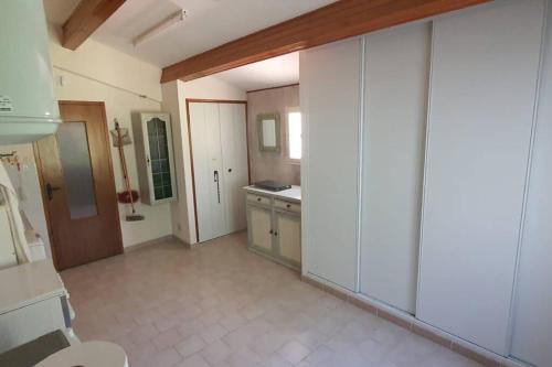 une grande cuisine avec des placards blancs et un évier dans l'établissement Villa proche des Alpilles Spa, à Eyguières