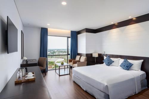 a bedroom with a bed and a living room at TUI BLUE Tuy Hoa - Wellness & Retreat Hotel in Tuy Hoa