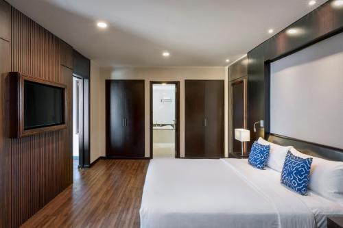 a bedroom with a large bed and a flat screen tv at TUI BLUE Tuy Hoa - Wellness & Retreat Hotel in Tuy Hoa