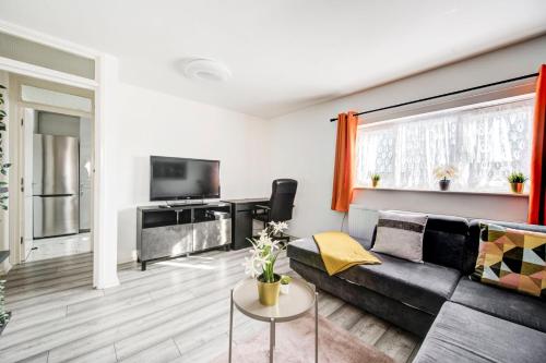 a living room with a couch and a tv at GuestReady - Urban Comfort near Wembley Stadium in London