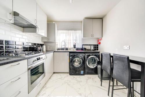 a kitchen with a washing machine in the middle at GuestReady - Urban Comfort near Wembley Stadium in London