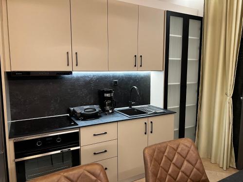 a kitchen with white cabinets and a stove top oven at Suite Rooms -Fine Living in Vévi