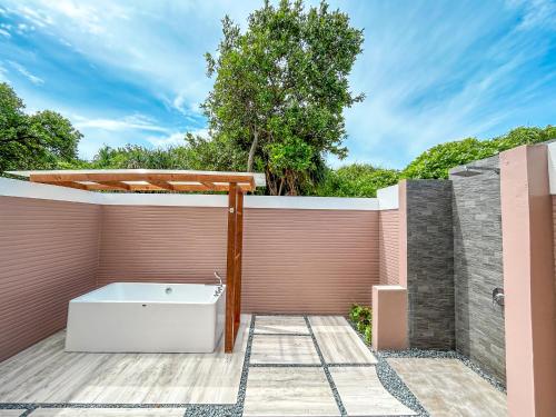 a bathroom with a bath tub on a fence at Kudafushi Resort & Spa in Raa Atoll