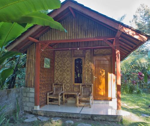 a small house with two chairs and a table at Tereng Wilis Jungle Inn in Tetebatu
