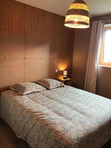 une chambre avec un grand lit avec une couverture bleue dans l'établissement Le Têr, gîte en Bretagne, à Saint-Dolay