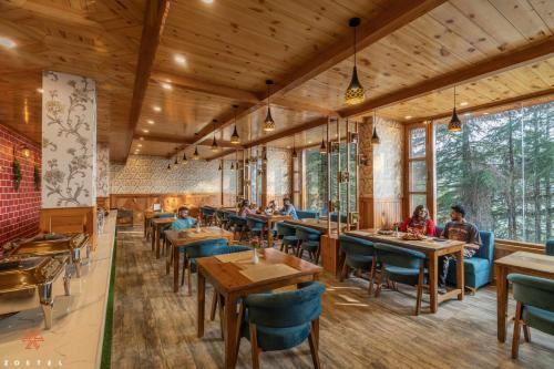 a restaurant with wooden ceilings and tables and chairs at Zostel Kotgarh, Narkanda in Kotgarh