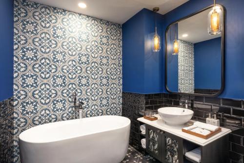 a bathroom with blue walls and a tub and a sink at TUI BLUE Tuy Hoa - Wellness & Retreat Hotel in Tuy Hoa