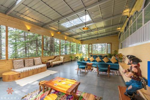 a large living room with a lot of windows at Zostel Kotgarh, Narkanda in Kotgarh