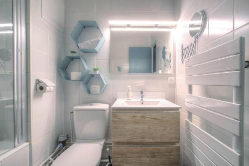 une salle de bain avec toilettes, lavabo et miroir dans l'établissement Appartement moderne proche Lyon 6ème, à Lyon