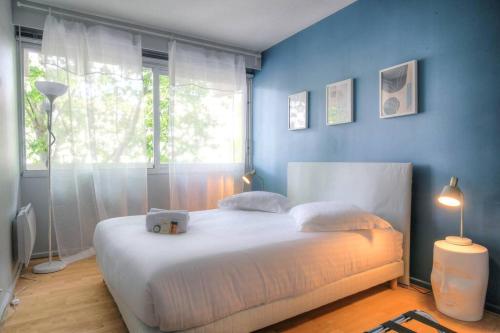 - une chambre avec un grand lit blanc devant une fenêtre dans l'établissement Appartement moderne proche Lyon 6ème, à Lyon