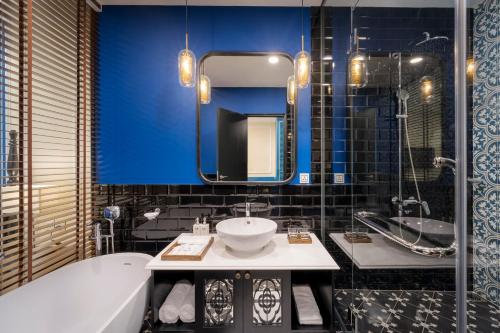 a bathroom with a tub and a sink and a mirror at TUI BLUE Tuy Hoa - Wellness & Retreat Hotel in Tuy Hoa