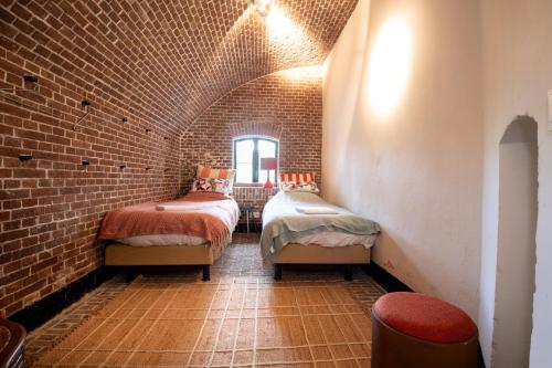 a room with two beds in a brick wall at Fort Vuren in Vuren