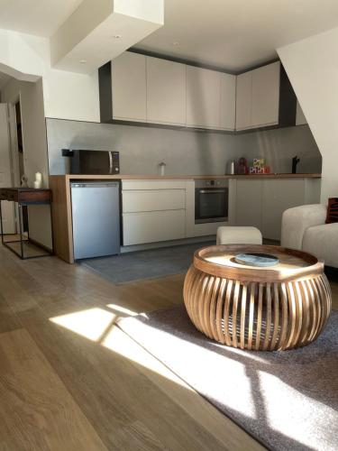 - une cuisine avec une table au milieu d'une pièce dans l'établissement MC Suite Briand CMZ Place-Ducale, à Charleville-Mézières