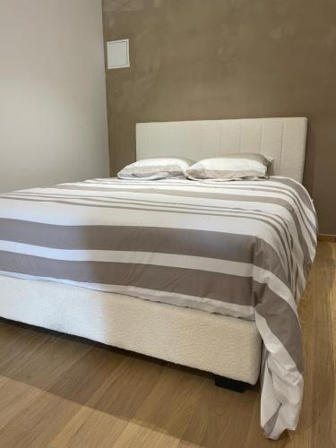 Una cama con sábanas blancas y almohadas. en MC Suite Briand CMZ Place-Ducale, en Charleville-Mézières