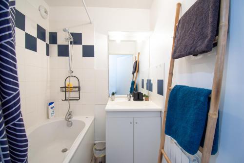 a small bathroom with a sink and a tub and a bath tub at L'Ecume dorée I Centre Ville & terrasse in Crozon