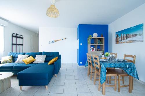 un salon avec un canapé bleu et une table dans l'établissement L'Ecume dorée I Centre Ville & terrasse, à Crozon