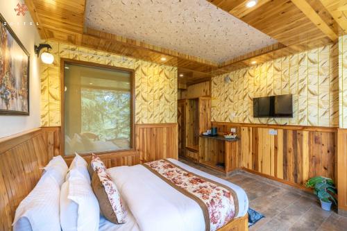 a bedroom with a bed in a room with wooden walls at Zostel Kotgarh, Narkanda in Kotgarh