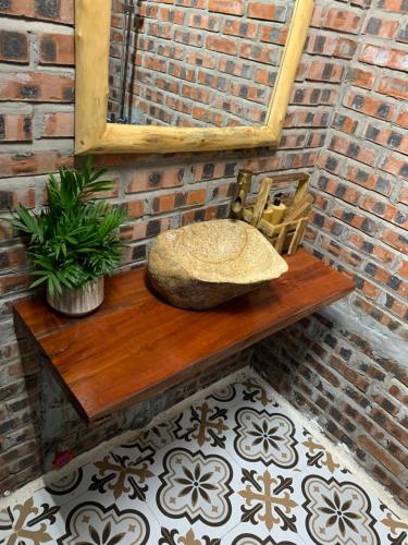 a rock sitting on a wooden table next to a brick wall at Peaceful refuge homestay in Ninh Binh