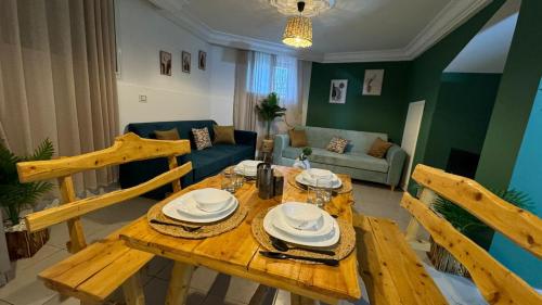a wooden table and chairs in a living room at Appartement in Mahdia