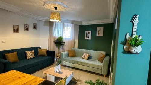 a living room with a couch and a guitar on the wall at Appartement in Mahdia