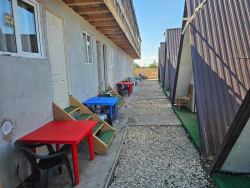 a row of tables and chairs next to a building at Ca la noi acasă in Costinesti