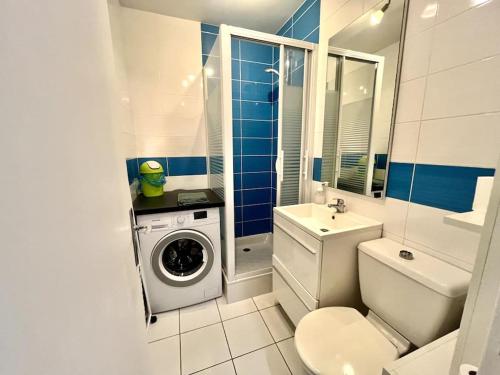 une salle de bain avec une machine à laver et un lave-linge dans l'établissement Gaudinière 2pers Tv wifi Parking, à Nantes