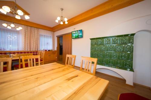 a dining room with a wooden table and a greenboard at Rojerhof in Schladming