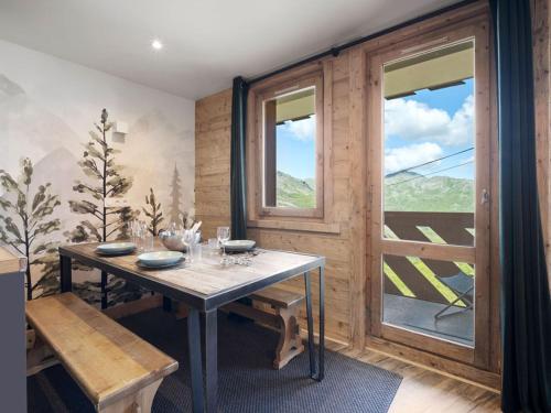 une salle à manger avec une table et une fenêtre dans l'établissement Appartement cosy aux pieds des pistes avec services inclus - FR-1-640-57, à Val Thorens