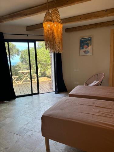 une chambre avec deux lits et un lustre dans l'établissement PORTO VECCHIO Santa Giulia Grand studio bergerie vue exceptionnelle mer et montagne, à Porto-Vecchio