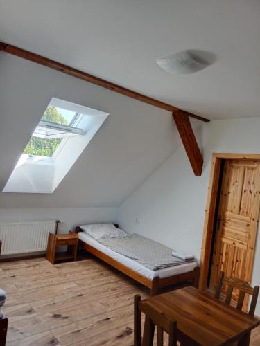 a bedroom with a bed and a window and a table at Penzion na Mlýně in Hradec nad Svitavou
