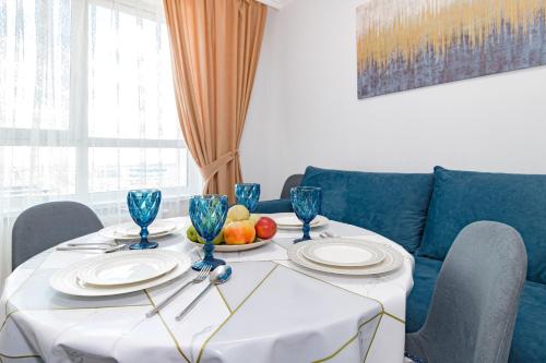 a table with plates and a bowl of fruit on it at Красивые апартаменты в жк Only Sun in Prigorodnyy