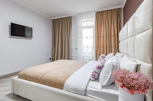 a bedroom with a large bed with flowers on it at Красивые апартаменты в жк Only Sun in Prigorodnyy