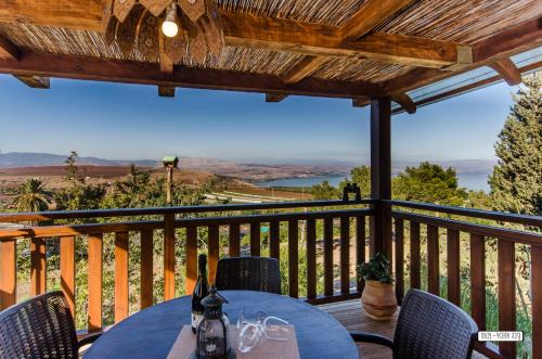 a patio with a table and chairs on a balcony at Beautiful Lake View Wooden House in Tiberias