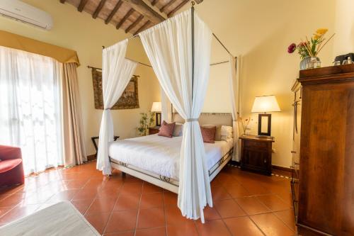 a bedroom with a bed with a canopy at Borgo San Luigi in Monteriggioni
